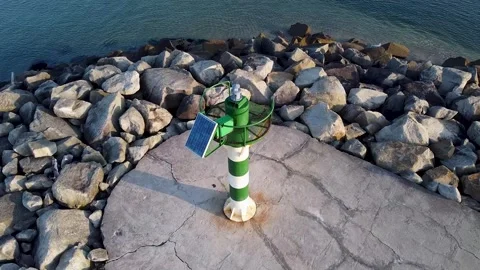 A Green and White Lighthouse on a Stone Breakwater. Concept The navigation .. 스톡 동영상 315611700