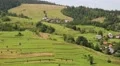 Green and yellow hills and houses with red roofs in village, Ukraine HD Footage