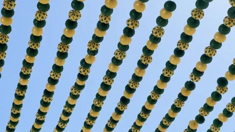 Green and yellow paper lanterns hanging for a Spanish festival against a clear Vídeo Stock 346596332