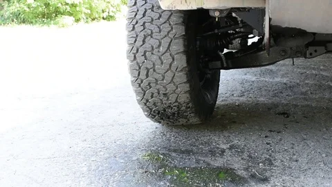 Green antifreeze flows out of the car onto the asphalt in summer Stockbeeldmateriaal 101239384