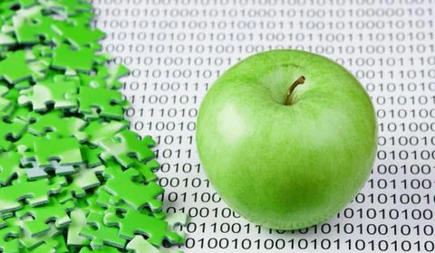 Green apple and puzzles on a binary code 库存照片