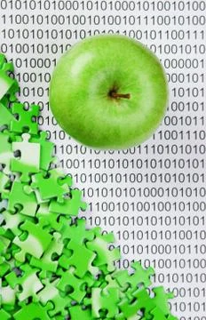 Green apple and puzzles on a binary code Stock Photos