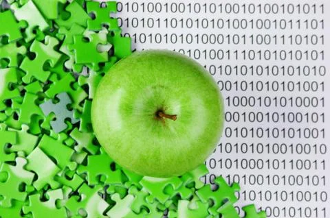Green apple and puzzles on a binary code Stock Photos