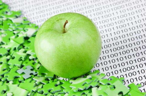 Green apple and puzzles on a binary code 写真素材
