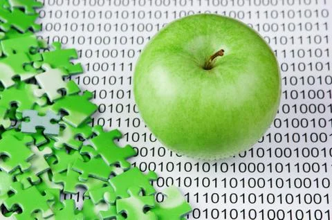 Green apple and puzzles on a binary code 스톡 사진