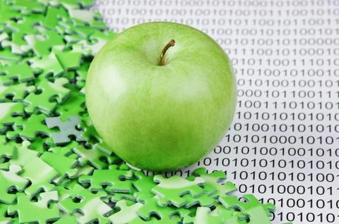 Green apple and puzzles on a binary code Foto stock