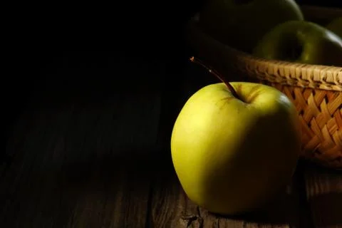 Green apple on a background of the baskets. Stock Photos
