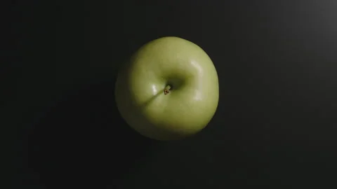 Green apple on a black surface. Top view. Stop motion Stock Footage 131588071