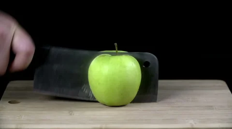 Green apple chopped up in half with a cleaver Video stock 33008471
