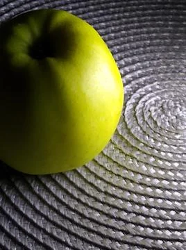 Green Apple close-up on a silver textured background with hard lighting Stock Photos