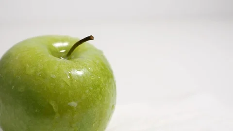 Green apple closeup cropped, splashed with drops of water Stock Footage 99262824
