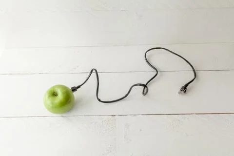 Green apple connected to an ethernet cable Stock Photos