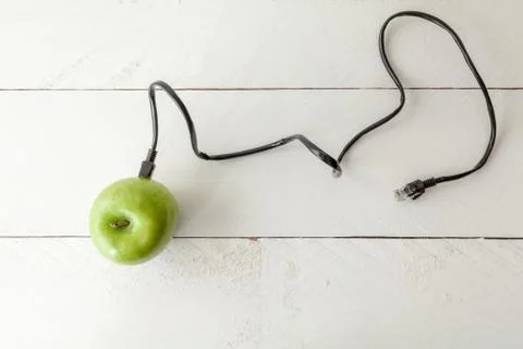 Green apple connected to an ethernet cable Stock Photos