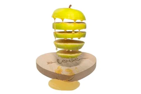 A green Apple drenched with honey flies over the Board in the form of a heart Stock Photos