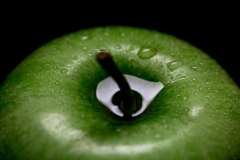Green apple with drops on dark background Stock Photos