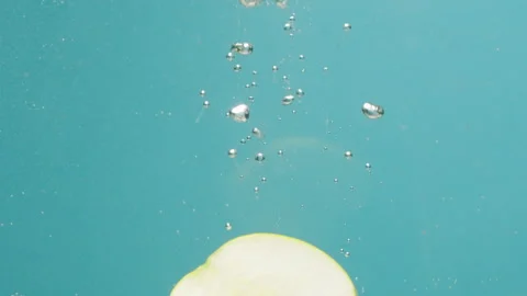 Green apple falling in boiling water, fresh sliced fruits and vegetables falling Stock Footage 255252307