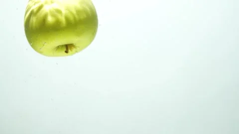 Green apple falls into the water with bubbles Stock Footage 256144394