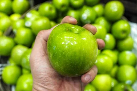 Green apple in hand Stock Photos