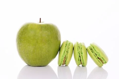 Green apple with macaroons Stock Photos