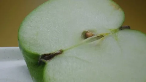 Green apple macro shooting,isolated half apple on yellow background rotates Stock Footage 130997152