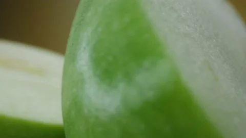 Green apple macro shooting,isolated half apple on yellow background rotates Stock Footage 130997221