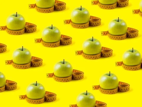 Green apple with measuring tape pattern on yellow Stock Photos