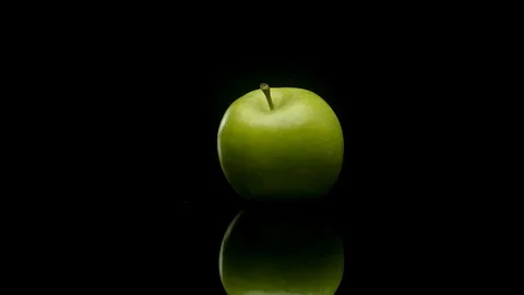 A green apple rotating on a black background 動画素材 128721468