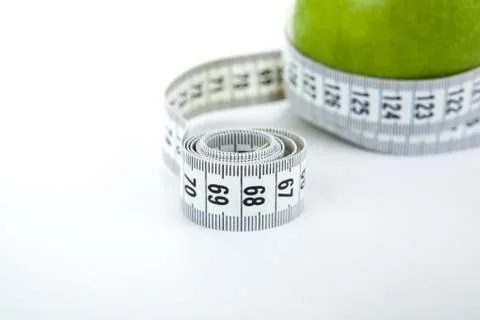 Green apple with a ruler Stock Photos