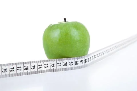Green apple with a ruler on a white background Stock Photos