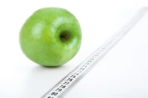 Green apple with a ruler on a white background Stock Photos