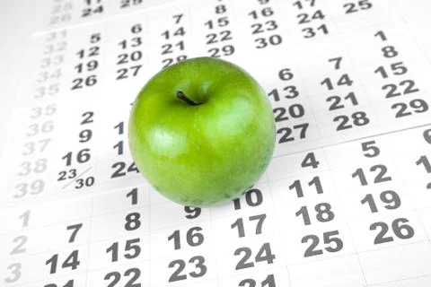 Green apple on sheets of wall calendar Stock Photos