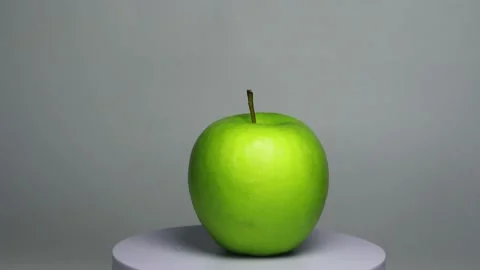 Green apple spinning on turning table with white background 스톡 동영상 182556036
