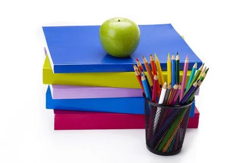Green apple on stack of colourful books Stock Photos