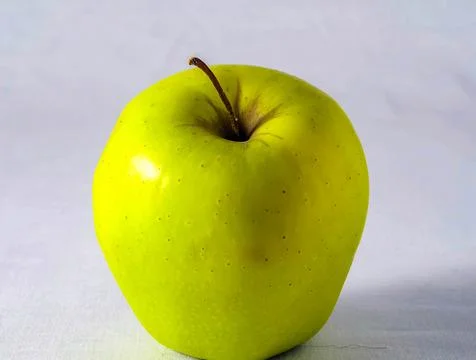 A green apple with a stem on top Stock Photos