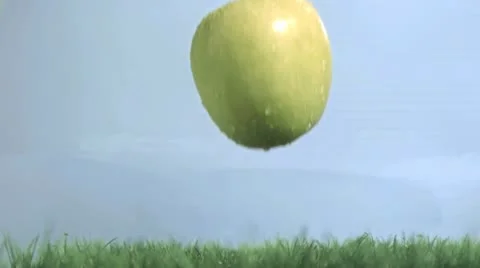 Green apple in super slow motion falling on the grass Stock Footage 10852940