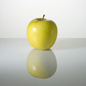 Green apple on a surface with reflection Stock Photos