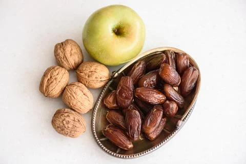 Green apple, walnuts and date fruits on white background Stock Photos