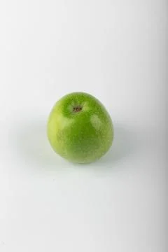 A green apple on white backdrop Stock Photos