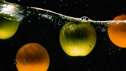 Green Apples and Oranges Fall Into Water. Slow motion Video Stock Footage 91721172