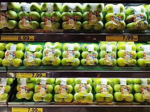 Green apples are exclusively packaged and displayed on the sales shelf Stock Photos