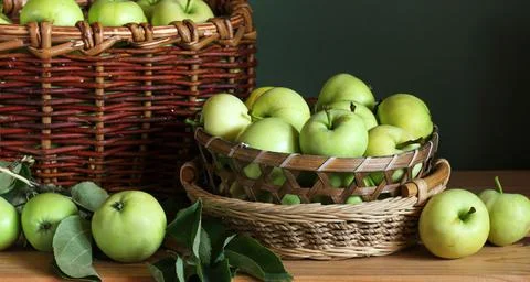 Green apples in baskets and on the table. Foto stock