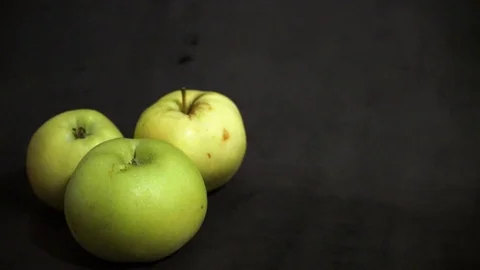 Green apples on a black background. fruit on black background. scattered apples. Stock Footage 99400926