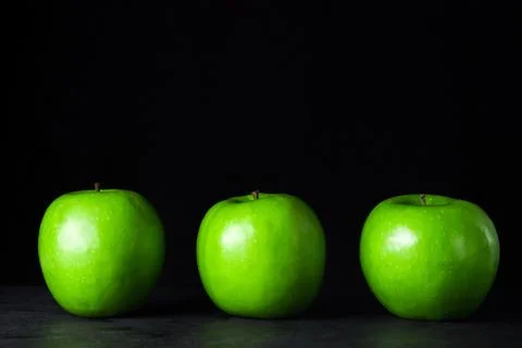 Green apples on a black background. Stock Photos