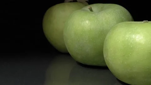 Green apples close-up. Ripe fruit on a black background. 動画素材 144353051