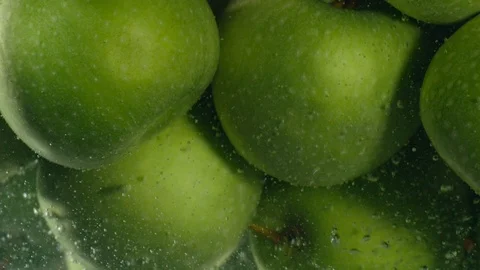 Green apples fall down in water against black background, super slow motion Stock-Footage 97439756