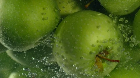 Green apples fall down in water against black background, super slow motion Stock-Footage 97439870
