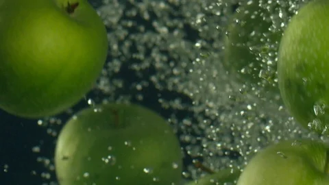 Green apples fall down in water against black background, super slow motion 스톡 동영상 97440186