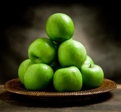 Green apples inside a basket Stock Photos