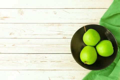 Green apples in a plate on table Stock Photos
