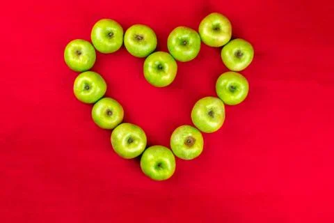 Green apples on a red background Stock Photos